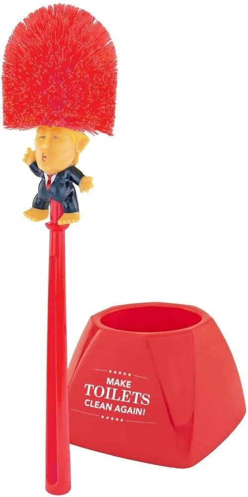 Novelty toilet brush with a handle sculpted to resemble Donald Trump in a red tie, paired with a red elephant-shaped base that holds the brush upright next to a toilet